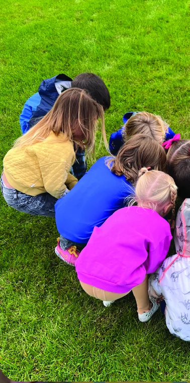 Preschool students exploring together outdoors